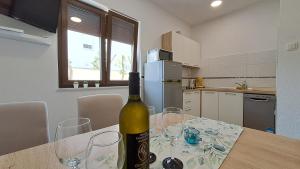 butelkę wina na stole w kuchni w obiekcie Apartments Hrusta w Crikvenicy