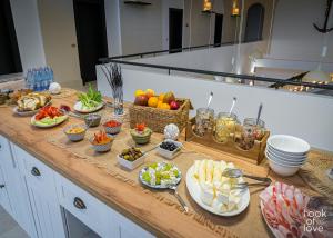 a buffet of food on a counter with plates of food at Hook Of Love - Le Mirage de la Mer in Olimp