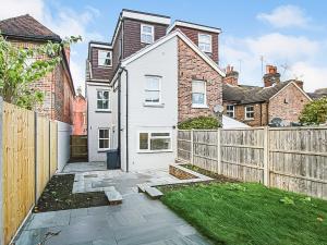 a white house with a wooden fence in a yard at Sahara Rose in East Grinstead