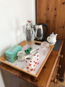 a wooden table with a tray with items on it at Lilac Villa Guest House in Weymouth