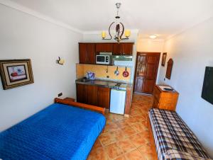 una pequeña cocina con una cama azul en una habitación en Mirador Golf Appart-hotel en Cabo Negro