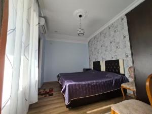 コブレチにあるGuest House Rustaveliの石壁のベッドルーム(紫色のベッド1台付)