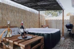 Zimmer mit einer Badewanne und einem Tisch mit Weingläsern in der Unterkunft La Contemporaine in Mérignac