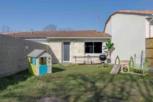 een kleine achtertuin met een huis en een grill bij La Contemporaine in Mérignac