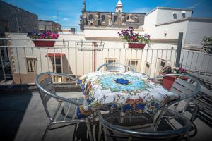 un tavolo con sedie su un balcone con tavolo e fiori di Pesci Suite a Spongano
