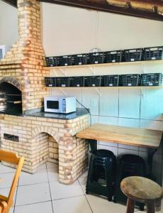 una cocina con encimera y un horno de ladrillo en Nossa Casa Arraial HOSTEL e SUÍTE, en Arraial do Cabo