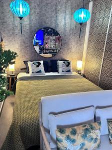 1 dormitorio con 1 cama con espejo y luces azules en LE GEISHA, en La Grande-Motte