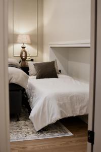 a bedroom with two beds and a table with a lamp at Boutique Vaksali Apartment in Viljandi