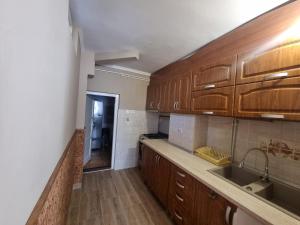 a kitchen with wooden cabinets and a sink at Silentium Clavem Domus II. in Satu Mare