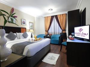 a hotel room with a bed and a flat screen tv at Boudl AL Salmiya بودل الكويت السالمية in Kuwait