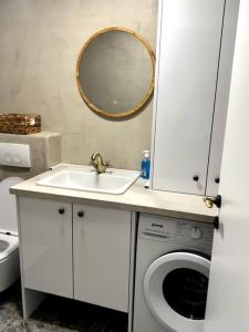 a bathroom with a sink and a washing machine at Sailor's apartment in Supetar