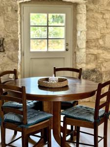 a wooden table with four chairs and a window at Sailor's apartment in Supetar