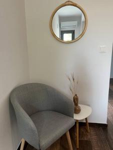 a chair in a room with a mirror and a table at Koroni Luxury Apartment in Koroni