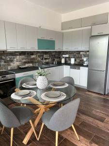 a kitchen with a table and chairs and a refrigerator at Koroni Luxury Apartment in Koroni