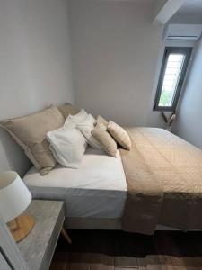 a bedroom with a bed with pillows and a window at Koroni Luxury Apartment in Koroni