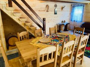 a dining room with a wooden table and chairs at CABANA GOTAN in Moisei