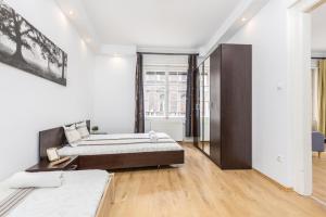 1 dormitorio con 1 cama grande y suelo de madera en Real Apartments Kertész, en Budapest