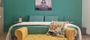 a bedroom with a bed with a yellow chair and the eiffel tower at CASADEI24 in Guidonia