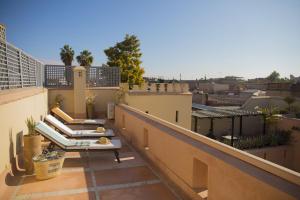 a balcony with chairs and tables on a roof at Riad Les Hirondelles Boutique Hotel in Marrakech