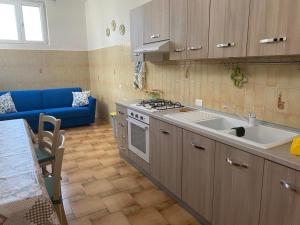 a kitchen with a sink and a blue couch at The Gods Brothers in Agerola