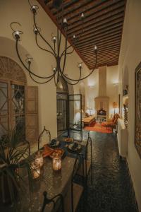 une salle à manger avec une table et un lustre dans l'établissement Riad Les Hirondelles Boutique Hotel, à Marrakech