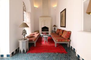 un salon avec un canapé et un tapis rouge dans l'établissement Riad Les Hirondelles Boutique Hotel, à Marrakech
