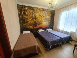 コブレチにあるGuest House Rustaveliのベッドルーム1室(ベッド2台付)が備わります。壁には絵画が飾られています。