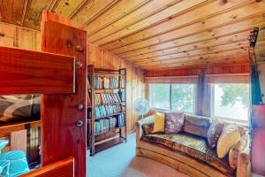 a living room with a couch and some books at Weeping Willow Cabin in Hayden
