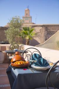 a table with a plate of food and a teapot at Riad Les Hirondelles Boutique Hotel in Marrakech