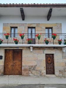 un edificio con macetas de flores en un balcón en alojamiento el árbol rojo, en Selaya