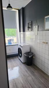 - un lave-linge dans la salle de bains pourvue d'une fenêtre dans l'établissement Stadtnah an der Förde 75 1, à Flensbourg