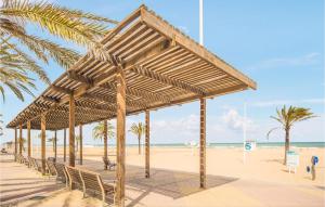 a wooden pavilion on a beach with palm trees at 3 Bedroom Cozy Apartment In Gandia in Gandía