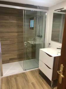 Un baño con ducha de cristal y lavabo. en Estudio Maria de Waard, en Nerja