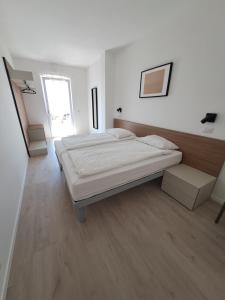 een witte kamer met een bed en een raam bij Appartamenti Elisabeth in Brenzone sul Garda