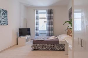 Dormitorio pequeño con cama y TV en Le suite di Borgo en Roma