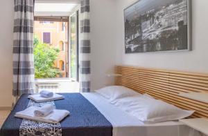 una camera da letto con un letto con due asciugamani e una finestra di Le suite di Borgo a Roma