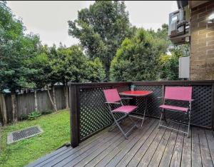 a patio with pink chairs and a table on a deck at Love Love Love ^^ in Hornsby