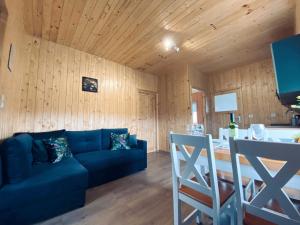 a living room with a blue couch and a table at Zielona Dolina Sarbinowo in Sarbinowo