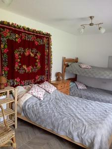 een slaapkamer met 2 bedden en een rode deken bij Sołtysówka in Wólka Nadbużna