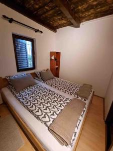a large bed in a room with a window at Holiday House River Mrežnica in Duga Resa