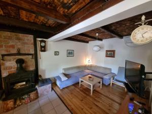 a living room with a blue couch and a fireplace at Holiday House River Mrežnica in Duga Resa