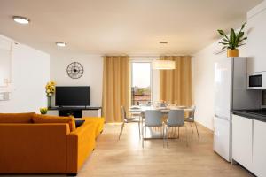 a living room with a yellow couch and a table at Apartman Oliva and Studio Delux for a family with swiming pool, free parking, terace with view at the sea in Podstrana