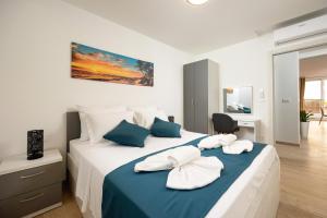 um quarto com uma cama grande e toalhas em Villa Ivka - Apartment Oliva & Studio apartment Deluxe em Podstrana