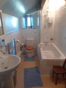 a bathroom with a tub and a toilet and a sink at Old Coach House in Matlock