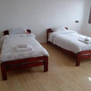 2 Betten in einem Zimmer mit Holzböden in der Unterkunft Appartement propre et spacieux Tan Tan Plage El Ouatia in Tan-Tan Plage