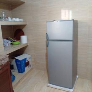 eine Küche mit einem weißen Kühlschrank im Zimmer in der Unterkunft Appartement propre et spacieux Tan Tan Plage El Ouatia in Tan-Tan Plage