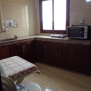 uma cozinha com um balcão com um micro-ondas e uma janela em Appartement propre et spacieux Tan Tan Plage El Ouatia em Tan-Tan Plage