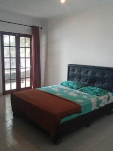 1 dormitorio con cama, ventana y puerta en CONDOMINIUM LIPPO PANTAI CARITA, en Carita