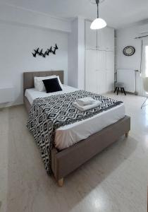 a bedroom with a large bed with a black and white comforter at Harmony home in Ierápetra