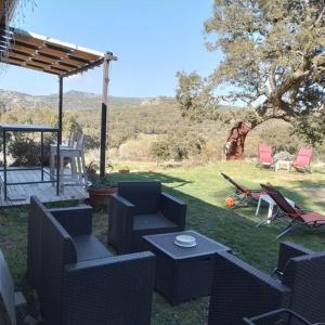 a patio with chairs and a table and chairs at Eco Lodge nella natura "La Grande Quercia" in Calangianus